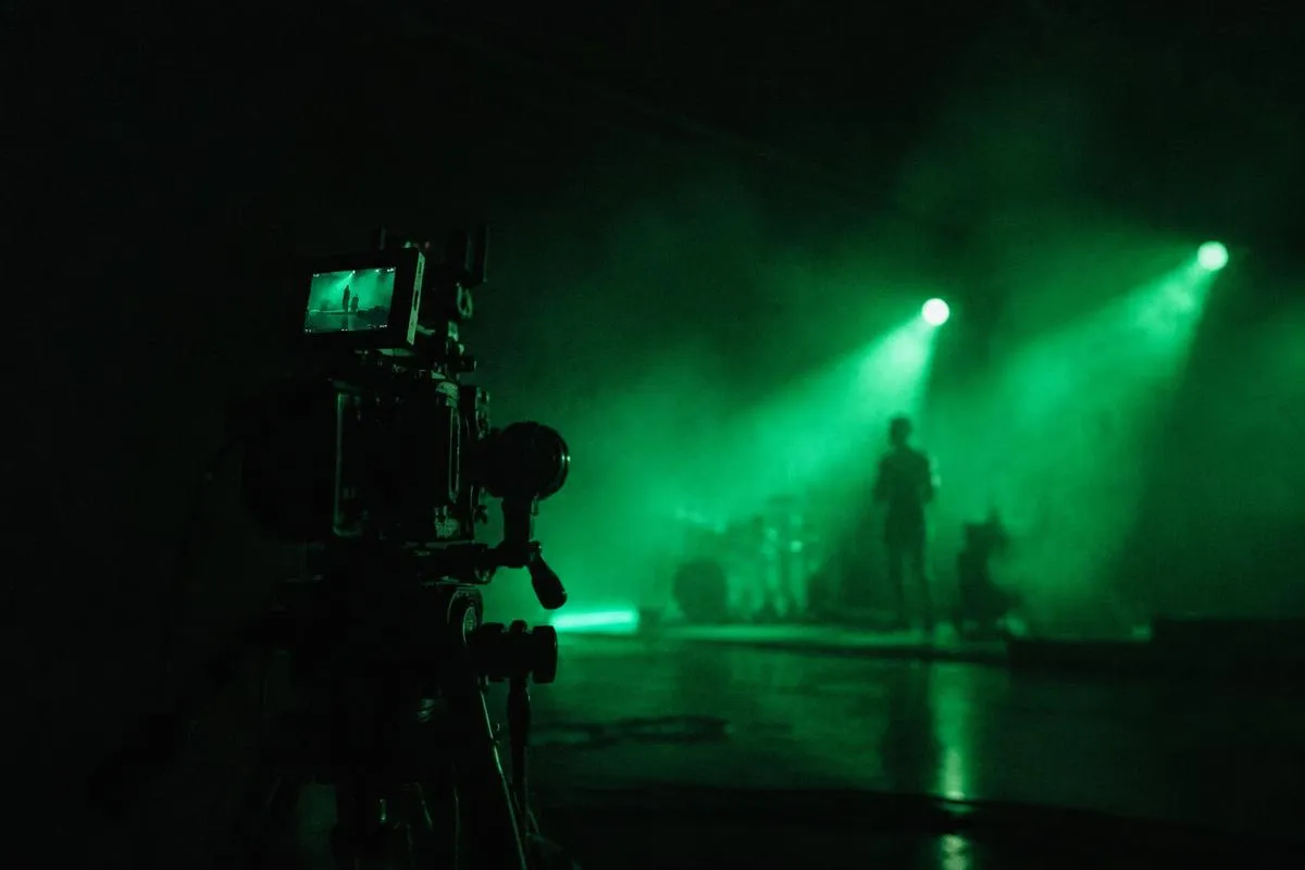Film camera pointed at a green lit stage